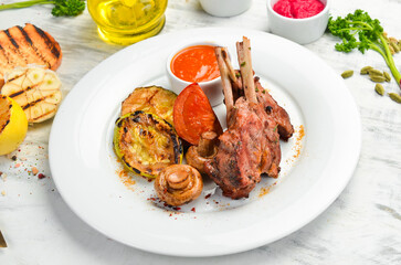 Lamb bone steak with vegetables on a plate. Top view.