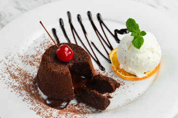 Dessert. Traditional chocolate fondant with ice cream and chocolate on a plate. Top view.