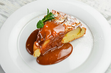 Dessert. Biscuit apple pie with caramel topping on a plate. Top view.