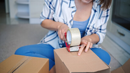 Closeup shot of a Caucasian woman packaging the boxes