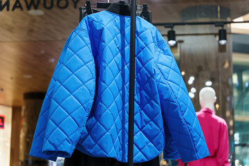 Blue jacket on hanger at women's clothing store.