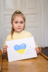 Ukrainian girl kid hands protesting against war conflict and holding message text "I want peace". Painted heart with Ukrainian colours flag. No war, stop war, russian aggression, crisis, peace