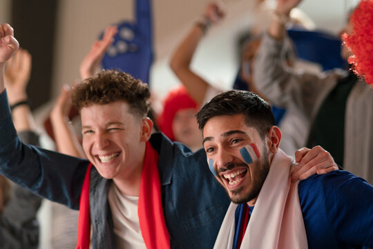 French football fans celebrating their team's victory at stadium.