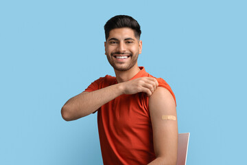 Coronavirus Immunization. Portrait Of Vaccinated Arab Guy With Adhesive Band On Shoulder