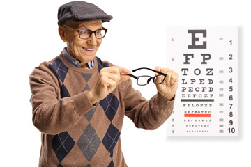 Elderly man trying on eyeglasses in front of a vision test