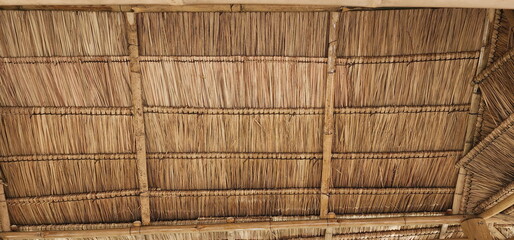 View from the southern side of a traditional thatched roof in a rural village. That thatched roof can be sunproof and rainproof. And good ventilation The history of hay or old hay.Straw Roof abstract 