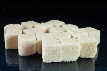 Sugar cubes on a glass table with reflection