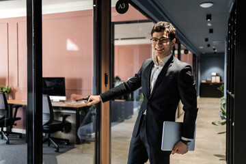 A manager in glasses and a business suit works in an office coworking space
