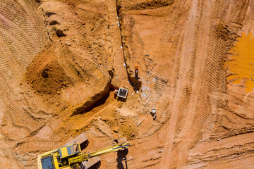 Aerial top view of construction site laying concrete pipe drainage system