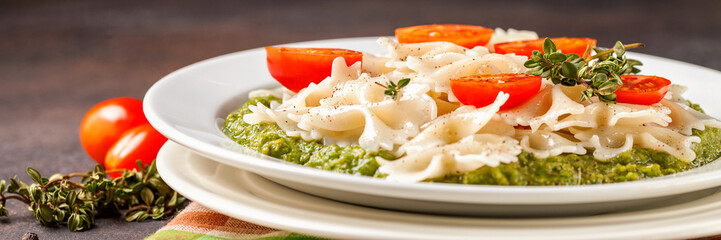 Paste with tomatoes and spinach sauce in a plate on a table. Selective focus. Copy space
