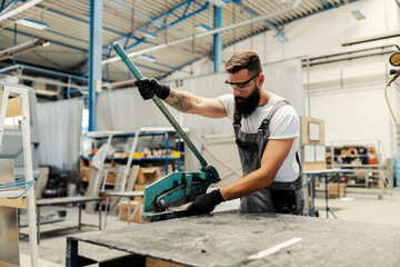 Fototapeta na wymiar A worker cutting metal parts at workshop.