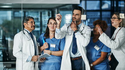 Medical brainstorming brilliance. Shot of a team of doctors having a brainstorming session in a hospital.