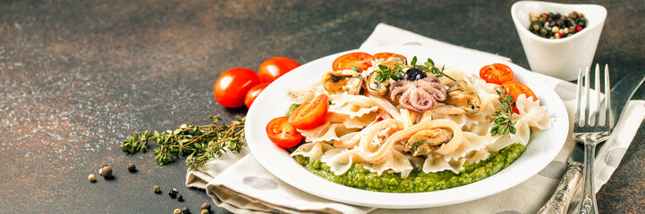 Paste with tomatoes, seafood and spinach sauce in a plate on a table. Italian food. Selective focus. Copy space