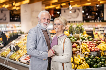 Senior couple holding hands at supermarket.