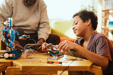 A granddad and his grandchild building a robot at home.