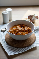 Chicken tikka masala dish bowl on a wooden table