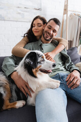 happy young woman hugging boyfriend near australian shepherd dog.