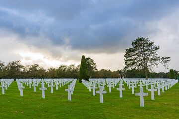Endless rows of white crosses under a spectacular cloudy sky at the impressive American military cemetery near Colleville-sur-Mer in Normandy, France