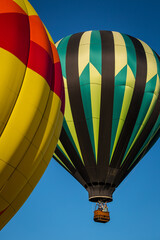 Closeup of hot air balloons flying over Bend, Oregon against a clear, blue sky