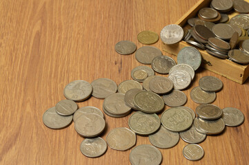 old collector's coins from different countries on a wooden background, space for text.