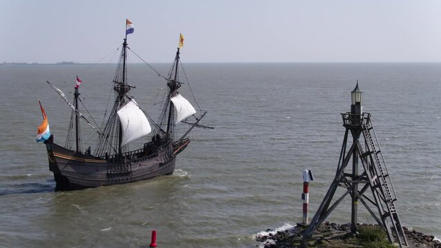 Replica VOC ship sail out of Hoorn harbour past Small Lighthouse; aerial
