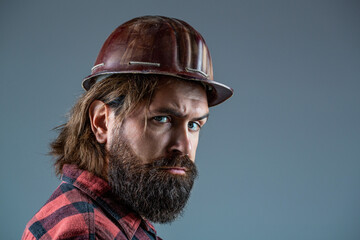 Obraz premium Building, industry - builder concept. Bearded man worker with beard in building helmet or hard hat. Man builders, industry