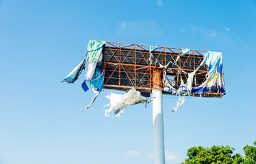 Broken metal billboard in blue sky