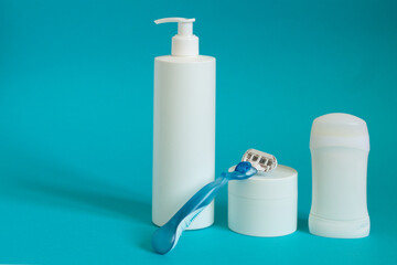 Various cosmetic products with deodorant. Beauty care accessories, shaving set with razor and shaving cream on blue background.