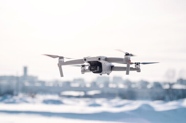 Modern gray drone in flight over the city. New technology. Blurred background.