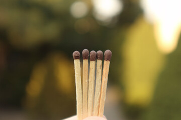 Matches in hand, fingers holding matches. Matches on the background. Unburned matches