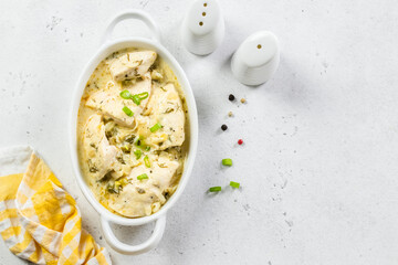 Chicken fillet garlic parmesan cream sauce in ceramic dish. Space for text, top view.