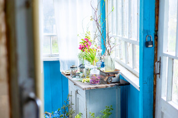 Vintage cupboard on veranda on sunny spring day decorated with flowers, Easter retro decor and...
