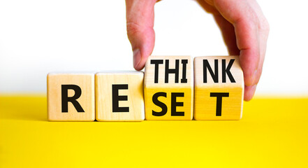 Rethink and reset symbol. Businessman turns wooden cubes and changes the concept word Rethink to...