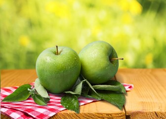 Green Apple fruit in wooden basket on natural garden background.