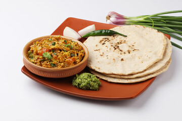 indian village food roasted egg plant and bhakri or Indian flat bread  Jowar Roti served with green...