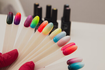 Naklejka premium Master holding different nail polish colors.