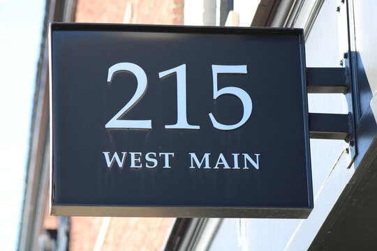 Closeup shot of a sign with a "215 West Main" writing