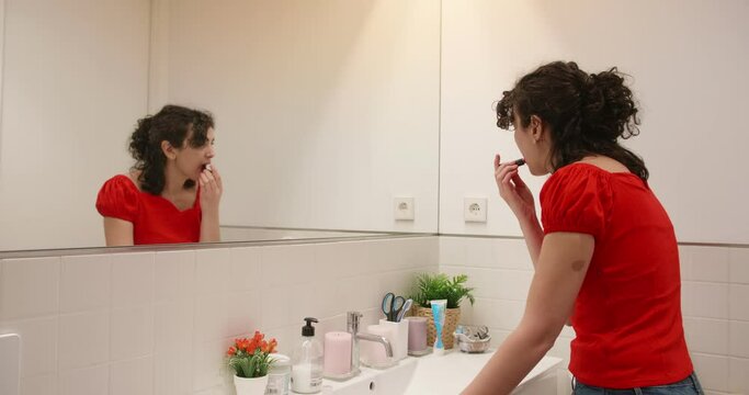 Woman In Front Of Mirror Using Lipstick