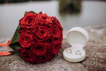 wedding rings lie on a beautiful box near bridal bouquet