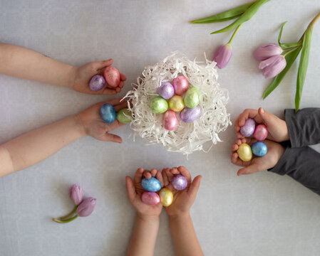 Children hands hold colourful Easter eggs. Easter is the main event for believers, timed coincide with resurrection of Jesus Christ. big happy family in love