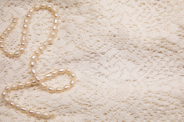 White pearls on the white knitted fabric background