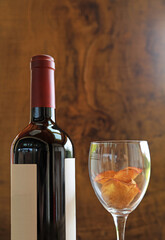 botella de vino tinto copa de cristal con pétalos fondo de madera 4M0A3729-as22