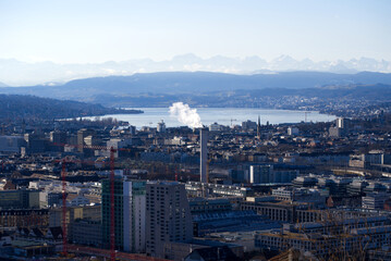 Aerial view over City of Zürich with Lake Zürich and Swiss Alps in the background on a blue and cloudy spring morning. Photo taken March 14th, 2022, Zurich, Switzerland.