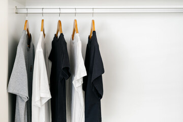 Shirts on wooden hangers on a rail inside wardrobe
