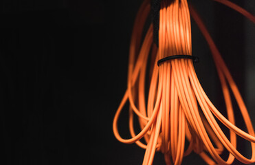 Roll of orange fiber optic cable on a black background