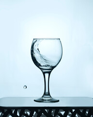 a glass of clean water with a splash on a light background