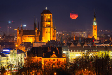 Fototapeta na wymiar Cityscape of Gdansk with St. Mary Basilica and City Hall with the full moon, Poland.