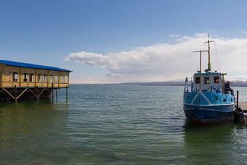 Fototapeta na wymiar The blue ship stands at the pier of Lake Sevan. Armenia