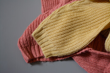 Various colors baby sweaters on dark gray background