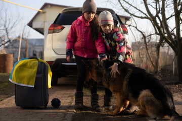 Ukraine military migration. two little girls with a suitcase. Flag of Ukraine, help. Crisis, military conflict